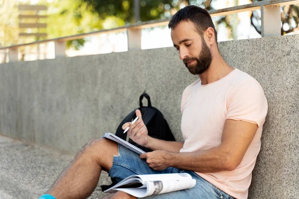 Handsome Pensive Man Holding Paper Notepad Taking Notes Writing Resume — Stockfoto