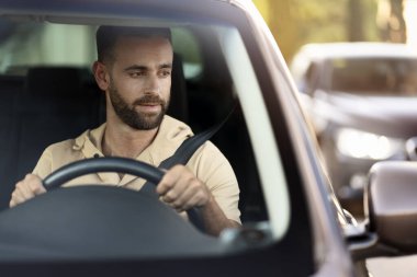  Serious handsome hispanic business man driving a car, copy space. Sad latin driver stuck in traffic