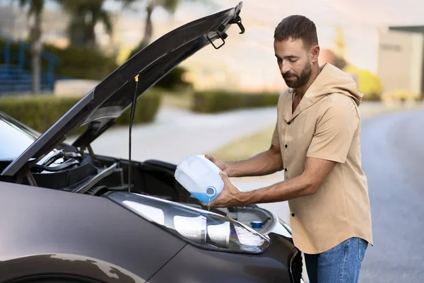 Latijnse Man Die Ruitensproeiervloeistof Giet Auto Reinigen Autoserviceconcept — Stockfoto