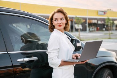 Kendine güveni tam orta yaşlı bir iş kadını elinde belgelerle sokakta yürürken başka tarafa bakıyor. Başarılı iş, kariyer.