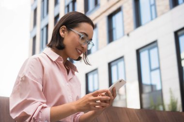 İnternetten mobil uygulama alışverişi yapan gülümseyen Asyalı kadın sokakta mesaj okuyor. Akıllı gözlüklü mutlu öğrenci akıllı telefon tutuyor, bir şeyler öğreniyor. 