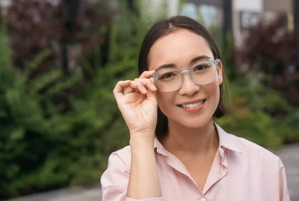 Portrait Smiling Asian Woman Corrects Stylish Eyeglasses Looking Camera Standing — Stock Photo, Image