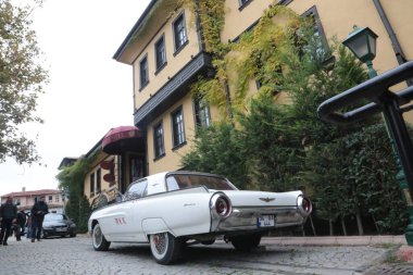 Vintage car in front of an old house