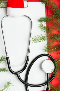 Noel Baba şapkasında steteskop ve boş bir pano olan tıbbi Noel konsepti