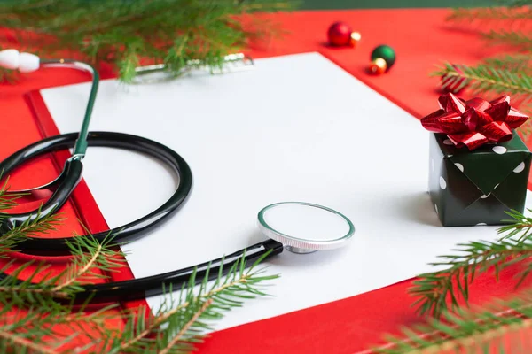 Medisch kerstconcept met stethoscoop, blanco klembord met wit papier Rechtenvrije Stockfoto's