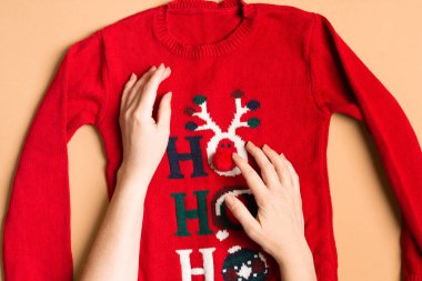 Noel süveteri ve kadın eli yeni yıl için kıyafet hazırlıyor.