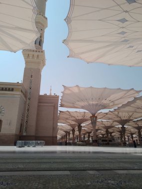 Medine, Suudi Arabistan - 07 Ekim 2022: El-Mescid An-Nabawi veya Peygamber Muhammed Camii meydanında Şemsiye inşaatı insanları gündüzleri güneşten koruyor ve geceleri aydınlık olarak çalışıyor