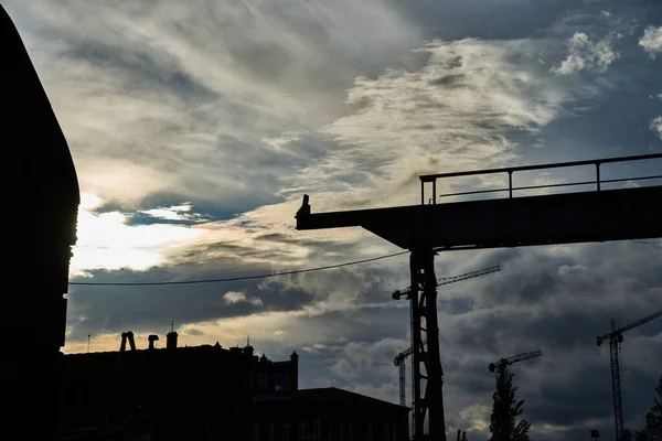 an old gantry crane in the shipyard against the setting sun
