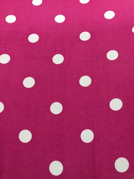 white polka dots on a pink background