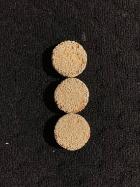 Siyah arka planda izole edilmiş susamlı bisküviler.