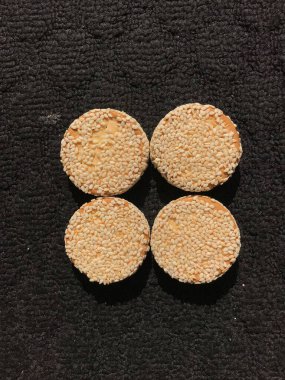 Siyah arka planda izole edilmiş susamlı bisküviler.