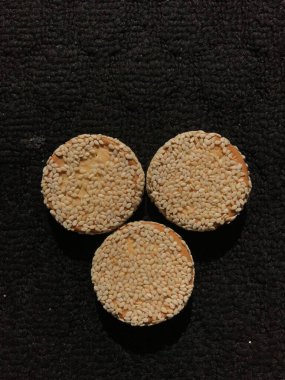 Siyah arka planda izole edilmiş susamlı bisküviler.