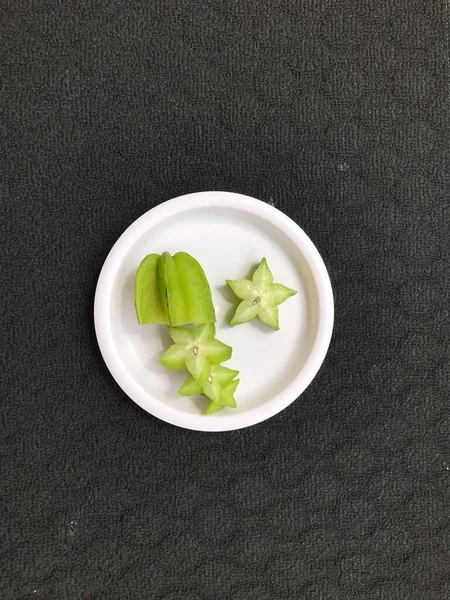 Yeşil Yıldız Meyve Dilimleri Pembe Plastik Bir Plaka Üzerinde Koyu — Stok fotoğraf