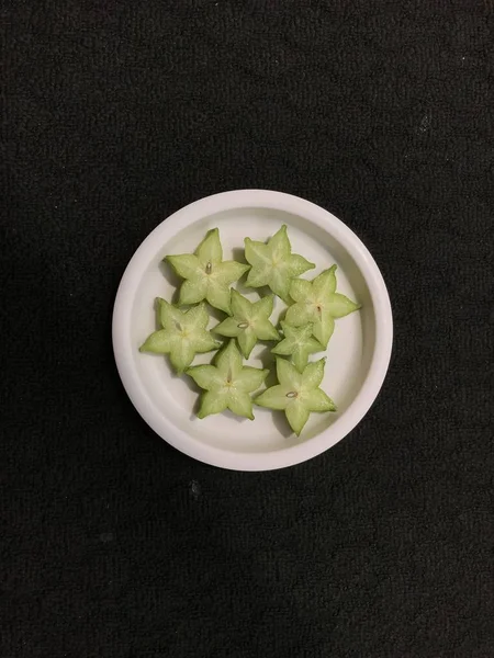 Fatias Frutas Estrela Verde Uma Placa Plástico Rosa Isolada Fundo — Fotografia de Stock