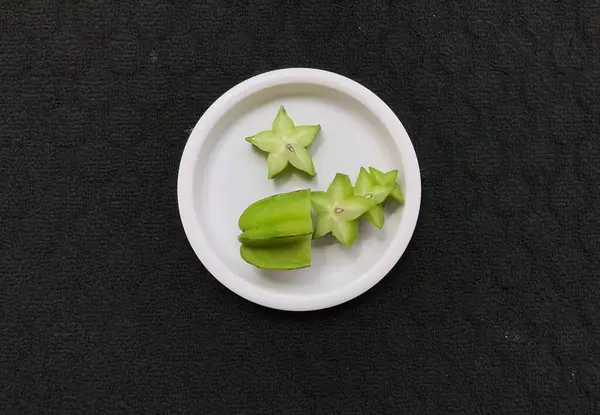 Yeşil Yıldız Meyve Dilimleri Pembe Plastik Bir Plaka Üzerinde Koyu — Stok fotoğraf