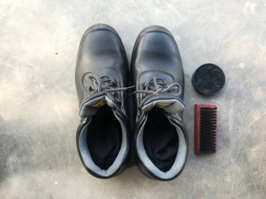 Ayakkabı fırçası ve ayakkabı cilasının yanında siyah güvenlik ayakkabısı. Çalışmaya hazırım.