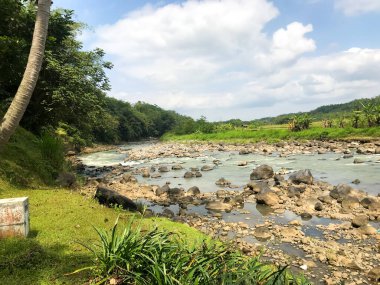 Mavi gökyüzüne karşı izole edilmiş doğal kayalarla dekore edilmiş nehir manzarası.