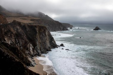 Big Sur Rocky Coastline with Pacific Ocean Waves and Stormy Sky