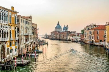 Venedik, İtalya 'da Büyük Kanal boyunca gün doğumunda Santa Maria della Salute, Venedik' te bir Roma Katolik kilisesi ve İtalya 'da küçük bir bazilika ile birlikte bir tekne.