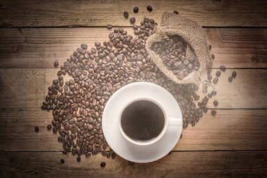 warm cup of coffee on brown background top view