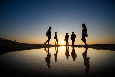 silhouette of friends in sunset on the sea