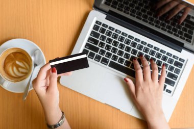 E-ticaret kavramı. Kredi kartı, dizüstü bilgisayar ve kahve, kadın ile yakın çekim