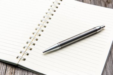 Ahşap masa üzerine dolma kalem ile defter