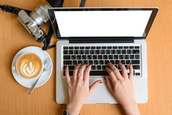 Female hands typing on a laptop keyboard with isolated screen and coffee relax time