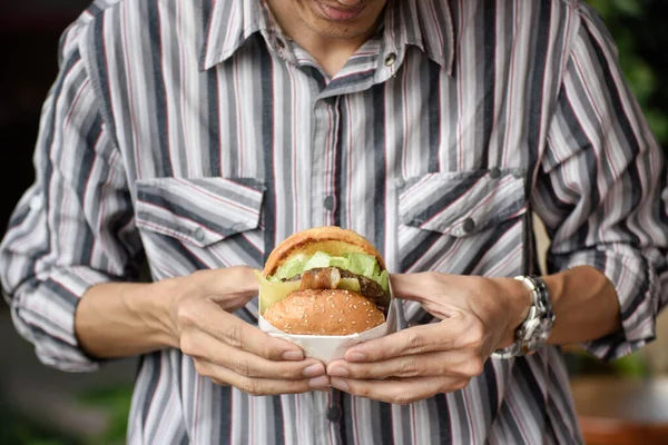 Attractive man is eating a hamburger