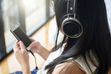 Kulaklıklı kadın müzik dinliyor.
