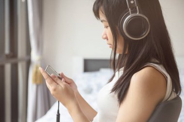 Kulaklıklı kadın müzik dinliyor.