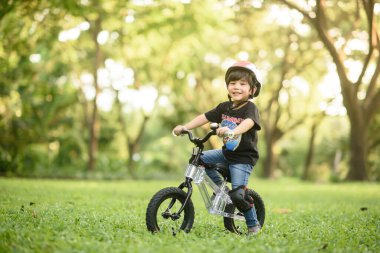 Bangkok Thailand - Oct 09, 2016 : happy cheerful child boy riding a bike in Park in the nature
