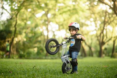 Bangkok Thailand - Oct 09, 2016 : happy cheerful child boy riding a bike in Park in the nature