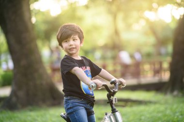 Bangkok Thailand - Oct 09, 2016 : happy cheerful child boy riding a bike in Park in the nature