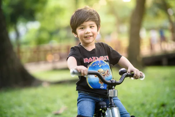 Bangkok Thailand - Oct 09, 2016 : happy cheerful child boy riding a bike in Park in the nature