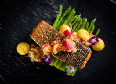 Tahta masada patates ve sebzeli kızarmış somon bifteği.