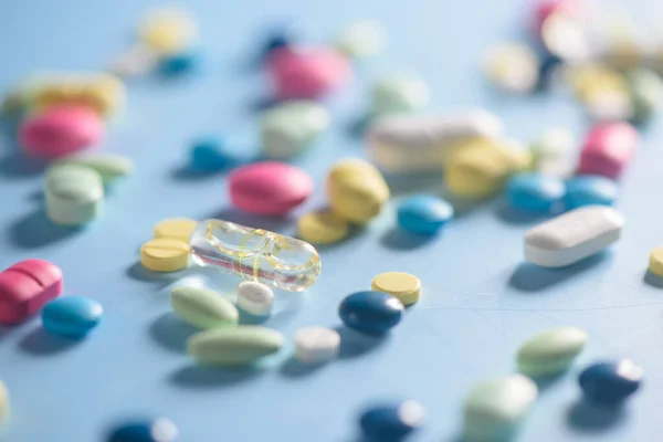 Pharmacy background on a  table. Tablets on a blue background. Pills. Medicine and healthy. Close up of capsules. Different kind of medicines