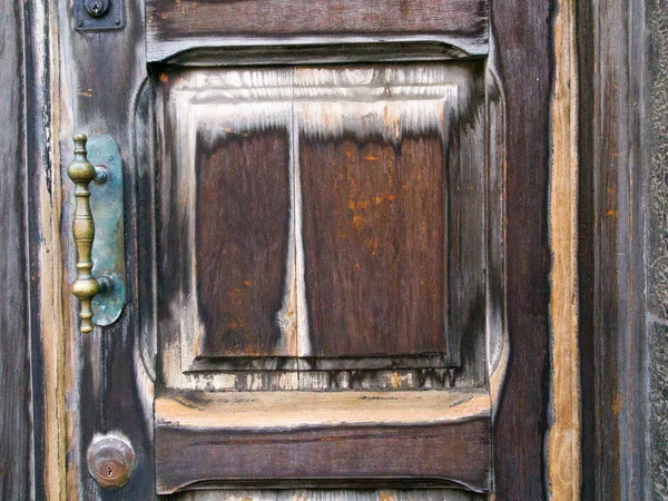 Kırsal bir sokakta eski ahşap bir kapı.