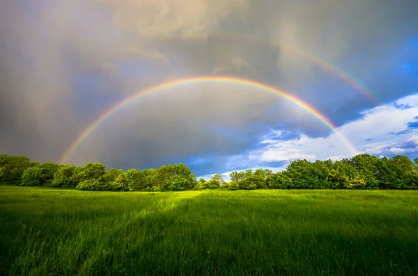 Double rainbow during the coming storm over the Czech green spring landscape