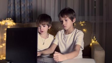 Kafkas çocuk ve kardeşi oturma odasında oturuyor ve dizüstü bilgisayar kullanıyor..