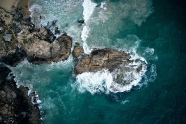 Gök mavisi okyanus dalgaları kayalara çarpıyor..