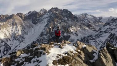 Kışın bir dağ manzarasında duran bir adamın hava çekimi. Kazakistan