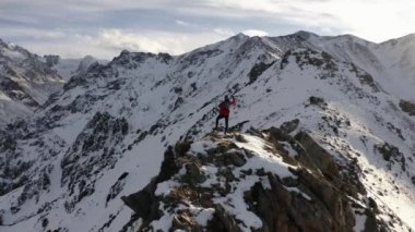 Kışın bir dağ manzarasında duran bir adamın hava çekimi. Kazakistan