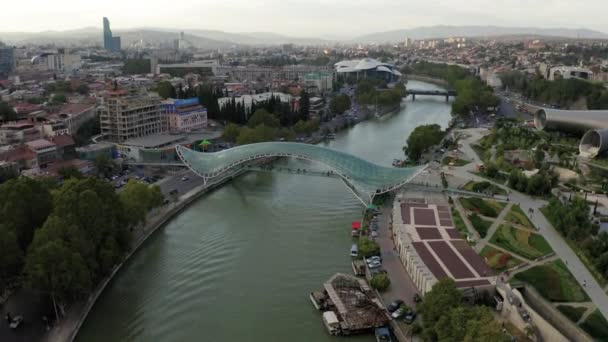 Imágenes aéreas de vídeo sobre la ciudad de Tiflis, Georgia. Puente de paz y Río Kura — Vídeo de stock