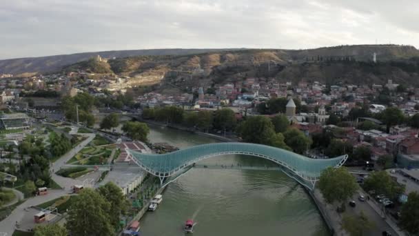 Imágenes aéreas de vídeo sobre la ciudad de Tiflis, Georgia. Puente de paz y Río Kura — Vídeo de stock