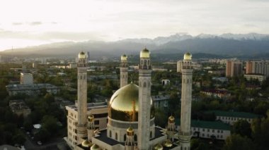 Almaty City, Kazakistan 'da güneş doğarken caminin üzerinde altın kubbe ile havadan uçuş.