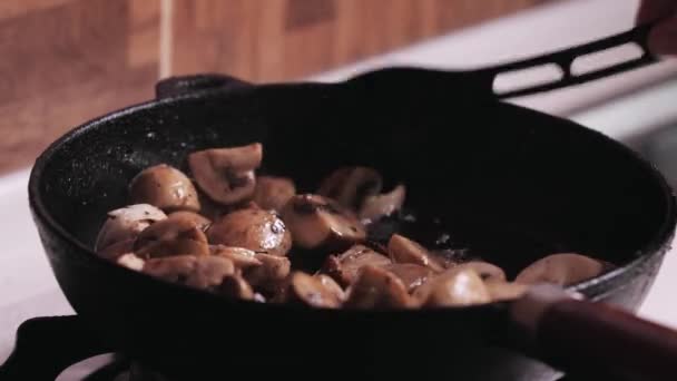 Close-up video of frying mushrooms in a pan and stirring — Stock Video