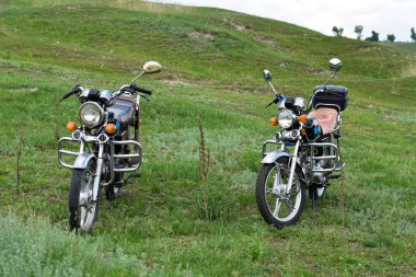 Old motorcycles parked on the grass at a festival