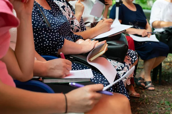 Group of women on chairs at a meeting, group meeting, taking notes