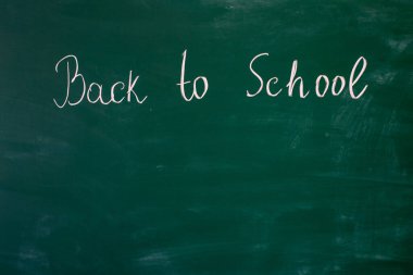 Blackboard at school, on which is written in chalk Back to school